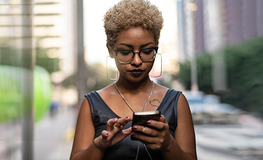 Mujer con un smartphone, usando el Asistente en vivo de Nuance 