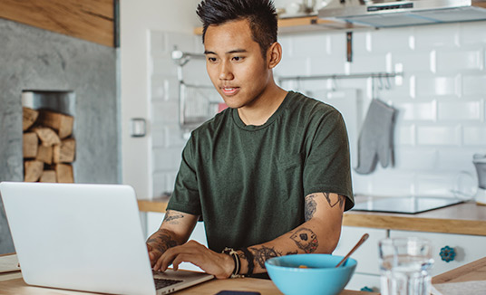 Mann mit Laptop in der Küche Mann mit Laptop in der Küche nutzt virtuellen Assistent und Chatbot-KI