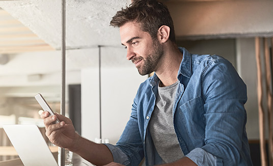 Hombre utilizando las soluciones digitales y de mensajería en su teléfono