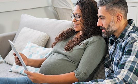 Couple with tablet researching healthcare customer engagement solutions