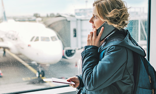 Mujer usando un smartphone para explorar la IA en soluciones para comercios minoristas y el sector hotelero