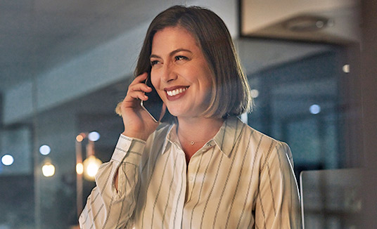 Kvinne som snakker i en smarttelefon Kvinne som snakker om Nuance samtalestyring i en smarttelefon