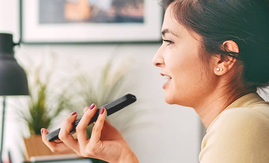 Mulher usando soluções de voz e URA do smartphone