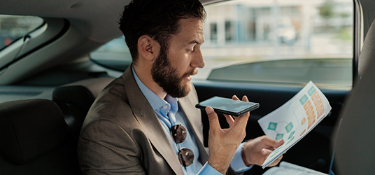 person in car looking at diagram and talking into mobile phone