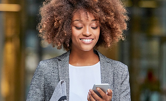 Sitzende Frau verwendet Enterprise-Messaging-Kanäle per Smartphone