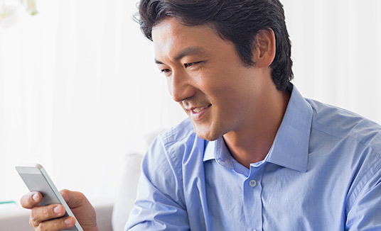 Man Looking at Smartphone Man looking at smartphone to explore AI-driven financial services