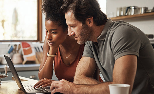 Vrouw en man gebruiken laptop om de mogelijkheden van AI voor de verzekeringsbranche te verkennen